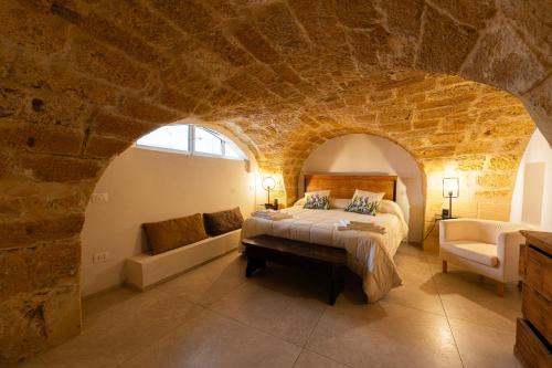 - une chambre avec un lit dans un mur en pierre dans l'établissement Ficupalas, à Syracuse