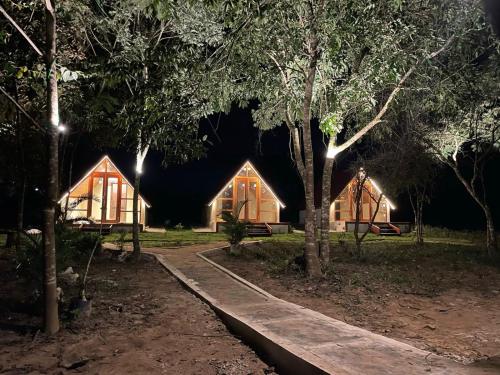 a couple of wooden cottages in a forest at night at Pousada Vale da Neblina in Ubajara