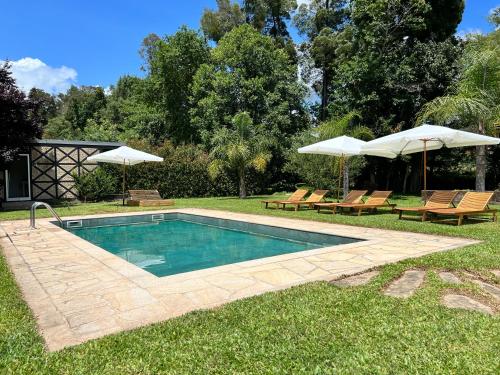 a swimming pool with two chairs and umbrellas at Quinta do Moinho da Ínsua in Ponte de Lima