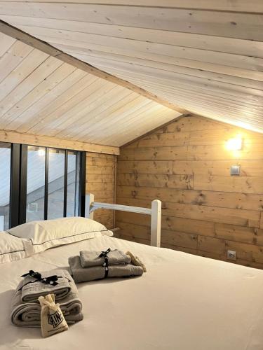 a bed in a room with a wooden wall at Le Petit Chalet Addicted to Paradise in Tignes