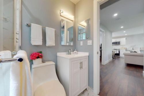 a bathroom with a sink and a toilet and a tub at Brand new house with an all year round hot tub. in Westhampton Beach