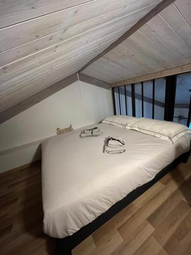 a large white bed in a room with wooden floors at Le Petit Chalet Addicted to Paradise in Tignes