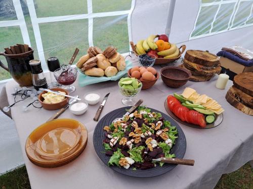 uma mesa com uma salada e outra comida em telšu vietas Divi Ozoli 