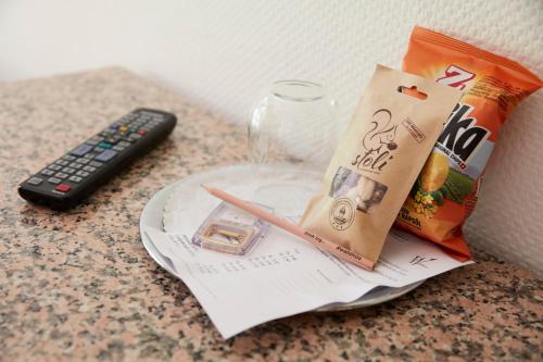 a counter top with a remote control and a bag of chips at Hotel Waldhaus in Bettmeralp