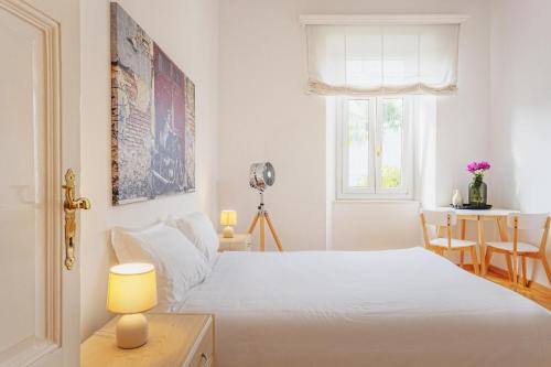 a white bedroom with a bed and a window at Villa Magnolia - Boutique Superior Rooms in Locarno