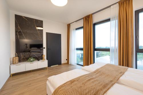 ein Schlafzimmer mit einem großen Bett und großen Fenstern in der Unterkunft Spichlerz Malbork in Malbork