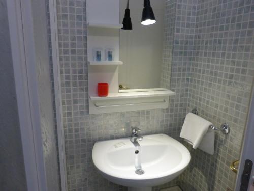 ボローニャにあるResidenza Piazza San Francescoのバスルーム(白い洗面台、鏡付)