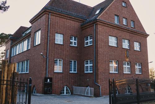 a large red brick building with white windows at Residence Black Eagle Lubmin Strand in Lubmin