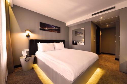 イスタンブールにあるインシティ ホテル ニシャンタシュのベッドルーム1室(白い大型ベッド1台付)