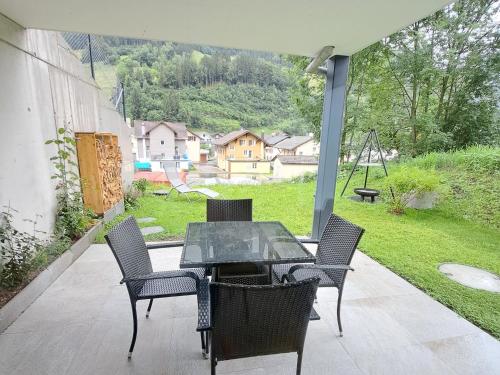 einen Tisch und Stühle auf einer Terrasse mit Schaukel in der Unterkunft Ferienwohnung Muota in Muotathal