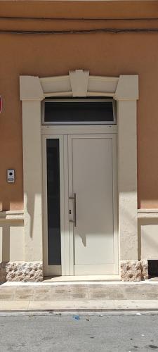 una gran puerta blanca en el lateral de un edificio en Impero5 Guest House, en Acquaviva delle Fonti