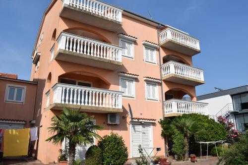 a tall orange building with white balconies on it at Apartments Lavanda in Crikvenica