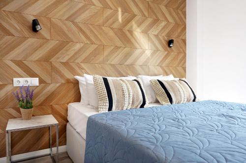 a bedroom with a bed and a wooden wall at Okean Apartments in Ierissos
