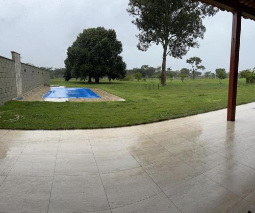 a swimming pool in a field with a tree at Sitio chácara rancho bonanza in Uberlândia