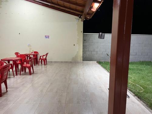 ein Zimmer mit roten Tischen, Stühlen und Gras in der Unterkunft Sitio chácara rancho bonanza in Uberlândia