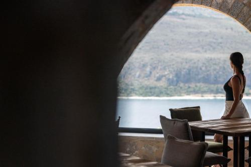 a woman sitting at a table in front of a window at Petra & Fos Boutique Hotel & Spa in Neon Oitilon