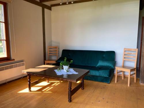 a living room with a green couch and a coffee table at LELB Rekolekciju centrs Mazirbē in Mazirbe