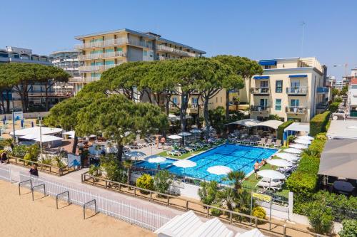 una vista aerea di un resort con piscina e ombrelloni di Hotel Excelsior a Lido di Jesolo