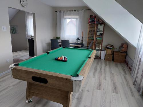 una mesa de billar en el centro de una sala de estar en Green Dream Apartment Szaunával, en Miskolc