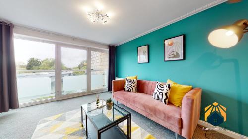 a living room with a couch and a large window at Stunning Cardiff City Apartment! Sleeps 8 in Cardiff