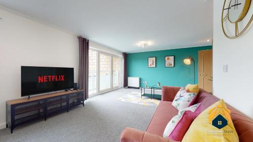 un soggiorno con divano e TV a schermo piatto di Stunning Cardiff City Apartment! Sleeps 8 a Cardiff