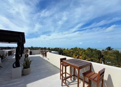 d'un balcon avec des tables et des chaises donnant sur l'océan. dans l'établissement 87979 Very chic 3BR Condo, tons of amenities, 1 block from Ocean, à Progreso