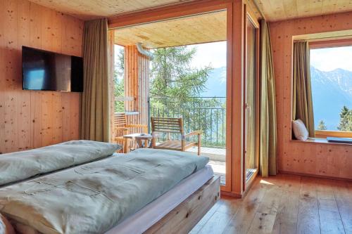 a bedroom with a bed and a large window at Hotel Waldhaus in Bettmeralp