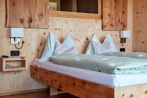 a bedroom with a bed with a wooden wall at Hotel Waldhaus in Bettmeralp
