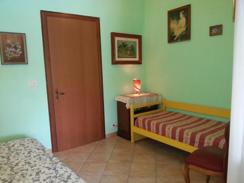 a small room with two beds and a door at B&B Le Amazzoni in Torre Chianca