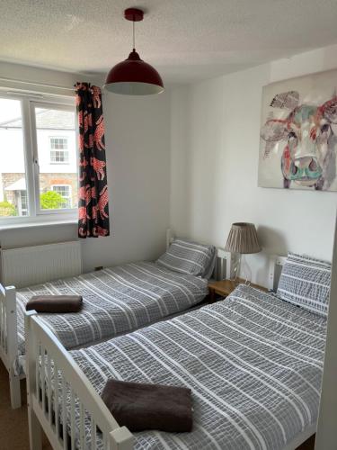 a bedroom with two beds and a window at Home in Buckland Brewer near Bideford in Bideford