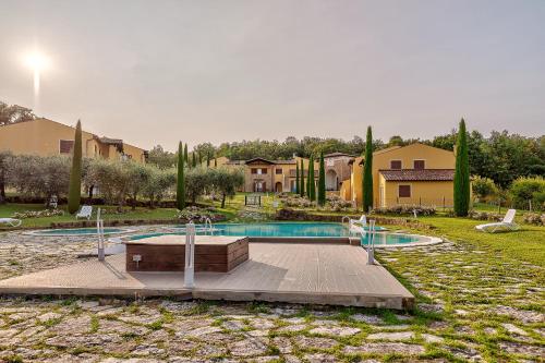 a swimming pool in a yard with trees and houses at Borgo del Faggio - Case Vacanza in Montepulciano