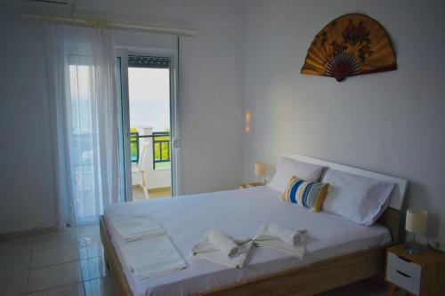 a bedroom with a white bed with a view of the ocean at Elegant Maisonettes Elena in Nea Potidaea