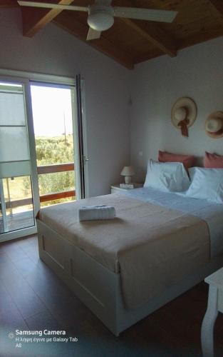 een slaapkamer met een groot bed en een groot raam bij Villa Raphael in Lixouri