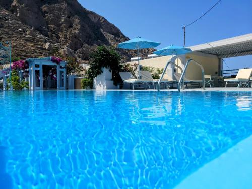 una piscina de agua azul y montañas de fondo en Villa Anneta, en Kamari