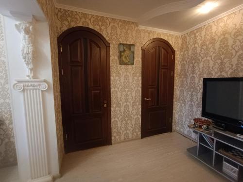 a living room with two doors and a television at Апартаменти район КРЕСа Сичеславська33 ''3кімн і 1кімн'' і Свирська1 "2кімн" in Kryvyi Rih