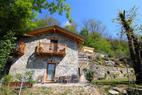 a stone house with a balcony on the side of it at Agriturismo Ai Ronchi in Sorico