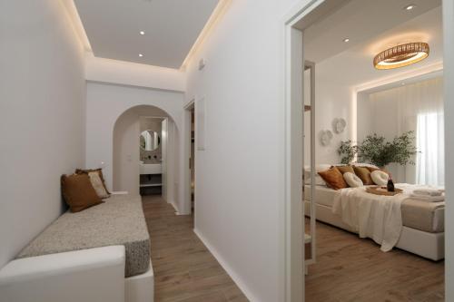 a white bedroom with a bed and a mirror at WOW Panoramic View Deluxe Villas in Agkidia