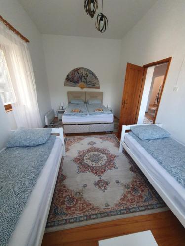 a bedroom with two beds and a rug at OLD HOUSE in Jajce