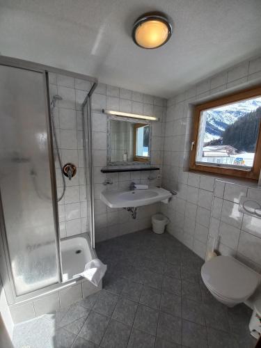 a bathroom with a shower and a sink and a toilet at Ferienwohnung CASADA im Hotel Casada in Galtür