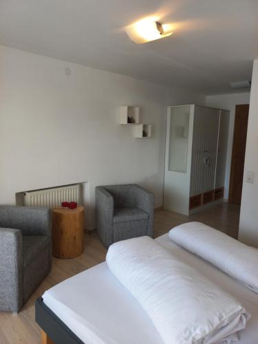 a room with two beds and a couch and a chair at Ferienwohnung CASADA im Hotel Casada in Galtür