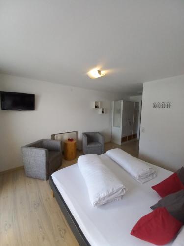 a bedroom with a large white bed and a couch at Ferienwohnung CASADA im Hotel Casada in Galtür