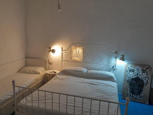 1 dormitorio con 2 camas y luces en la pared en da Massimo, en Santa Marina Salina