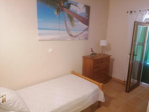 a bedroom with a bed and a dresser and a palm tree at Can Domingo in Sóller
