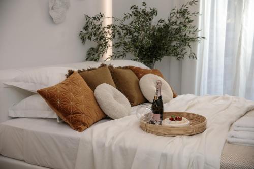 a bed with a basket of food and a bottle of wine at WOW Panoramic View Deluxe Villas in Agkidia
