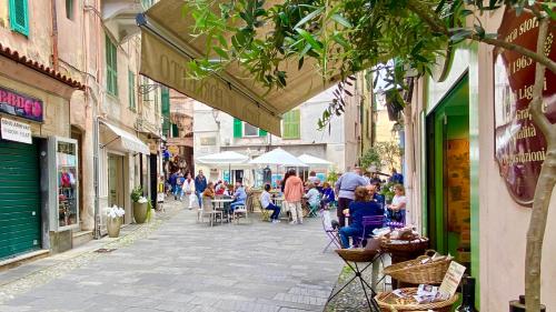 Une rue avec des gens assis à des tables dans une ruelle dans l'établissement I Tetti di Via Corradi, à Sanremo