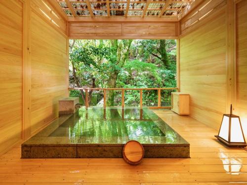a room with a pond in the middle of a room with a window at Mizumari in Kawazu