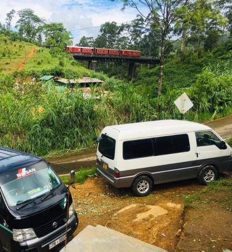 a white van parked on the side of a road with a train at Ansi Villa in Nanu Oya