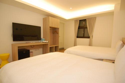 a hotel room with two beds and a flat screen tv at Season 5 Inn in Luodong