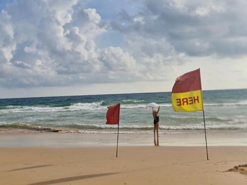 a person standing on the beach with two flags at The Naithorn Condo Unit 401 in Nai Thon Beach