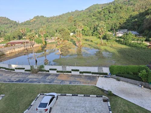 a white van parked in a parking lot next to a pond at The Naithorn Condo Unit 401 in Nai Thon Beach